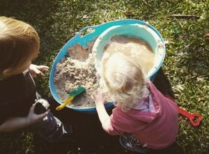 children playing with toys in washing up bowl